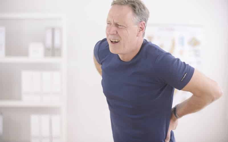 man with lower back pain holding back