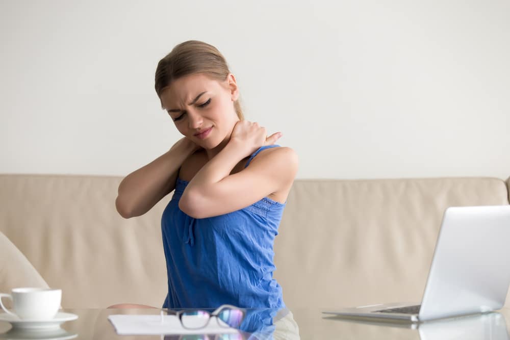 Tired woman feeling neck pain, massaging tense muscles